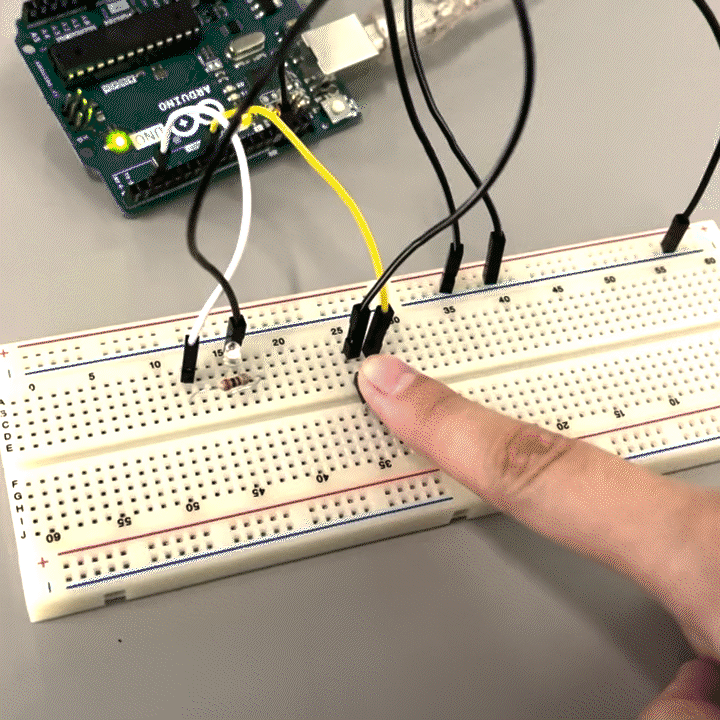 Arduino connected to a breadboard with an LED light, resistor and a physical button.